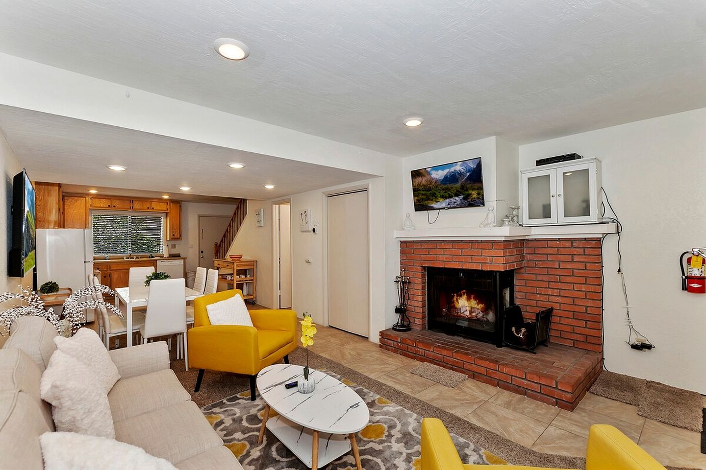 Una sala de estar con chimenea, un comedor y una cocina.