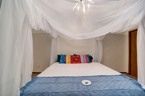 A bed with a canopy, colorful pillows, and a blue quilt. - Lovely Beach House Rental in Coastal Michigan, for Memorable Getaways to Muskegon (Muskegon)