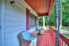A covered porch with wicker furniture and a red railing. - Lovely Beach House Rental in Coastal Michigan, for Memorable Getaways to Muskegon (Muskegon)