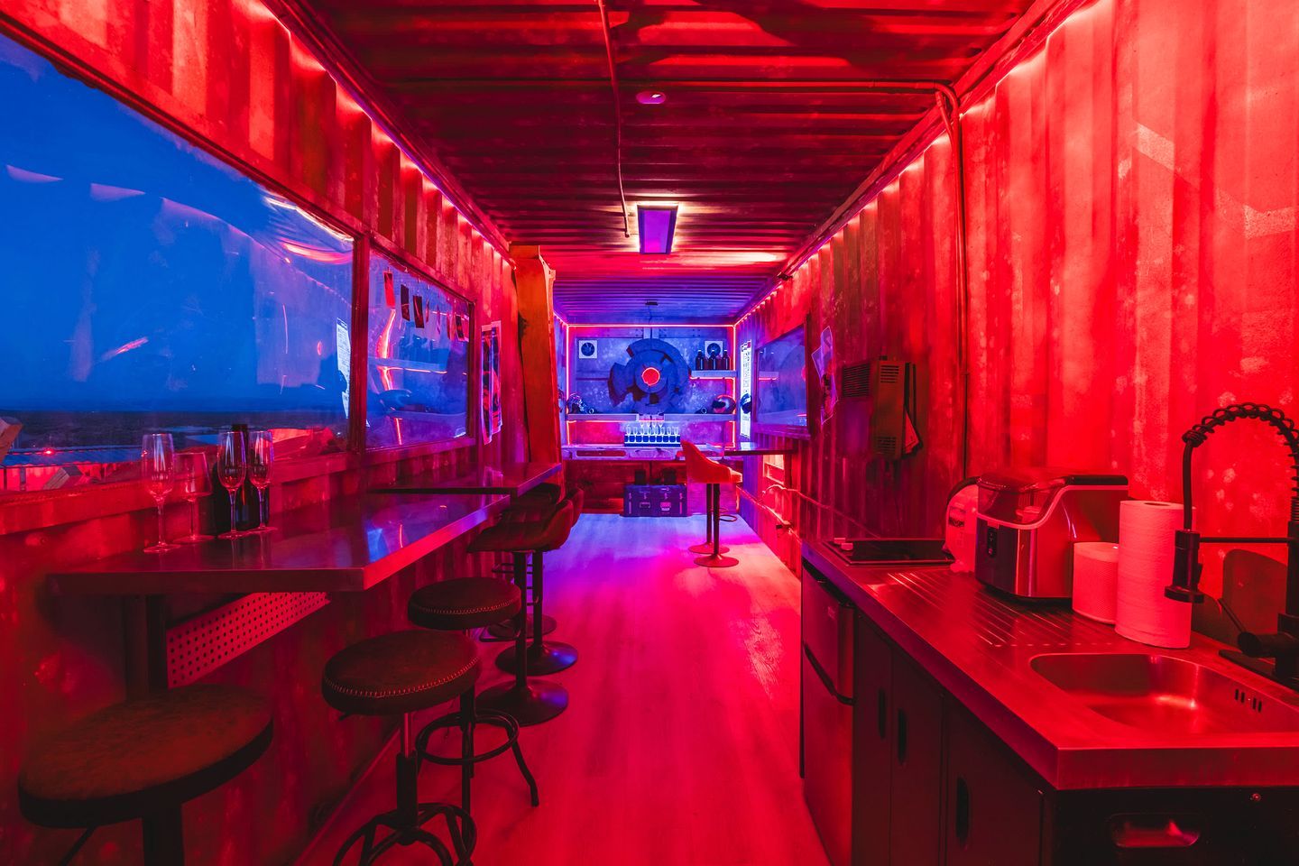 Eine Bar mit Sitzhocker, einer Theke und einer Jukebox.