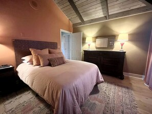 Ein Schlafzimmer mit Bett, Nachttisch, Kommode und Lampe.