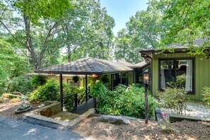 Ein Haus mit einer Veranda, einer Treppe und einem Garten mit unterschiedlichen Pflanzen.
