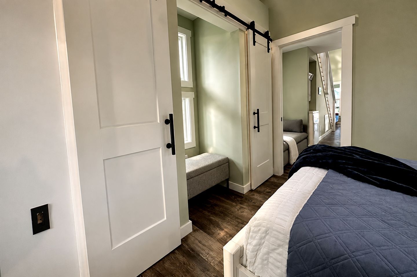 A bedroom with a bed, a bench, and a wardrobe with sliding doors.