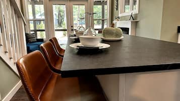 Una cocina con una encimera oscura, un tazón blanco y un tazón tejido verde sobre la mesa.