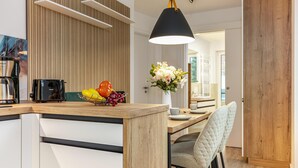 Eine moderne Küche mit einer Holzausziehtafel, einer Kaffeemaschine und einer Obstschale.