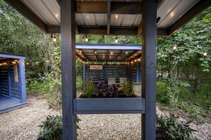 A covered outdoor seating area with a sign reading 'BAR SHOP' and a wooden structure labeled 'RELAX'. - Gorgeous Secluded Dome with Hot-tub in Broken Bow, Oklahoma (Broken Bow)