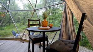 Una tenda amb una taula rodona, una cadira i un coixí a l'interior.
