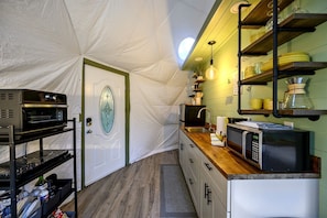 A compact kitchen with a built-in oven, microwave, and a small sink.