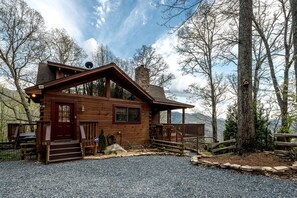 Eine Holzhütte mit Veranda, Schornstein und Kiesweg.
