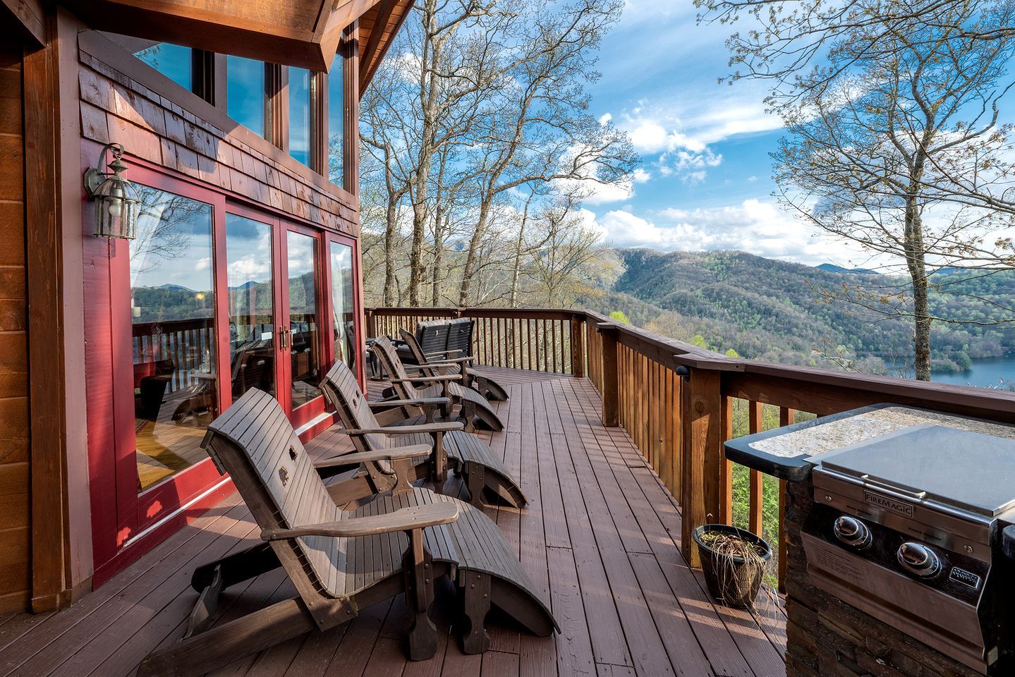 A wooden deck with outdoor seating and a grill.