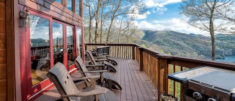 Eine Holzterrasse mit Sitzgelegenheit und Grill.