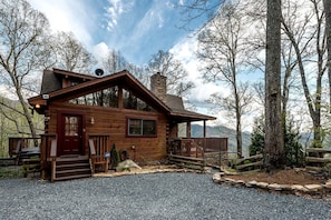 A wooden cabin with a porch, a chimney, and a gravel driveway. - Lakeview Cabin with Large Private Deck in Topton, North Carolina (Topton)