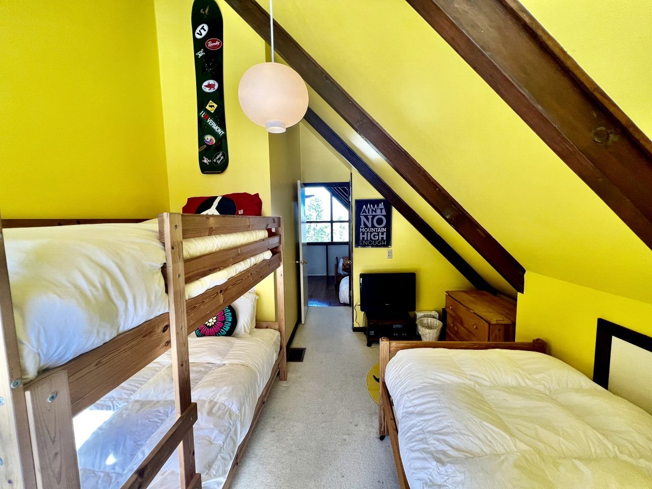 Ein Schlafsaalzimmer mit Stockbetten, einem Fernseher und einem Schild an der Wand.