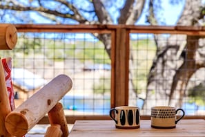Une table en bois avec deux tasses et une batte en bois.