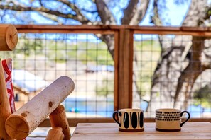 A wooden table with two mugs and a wooden bat.