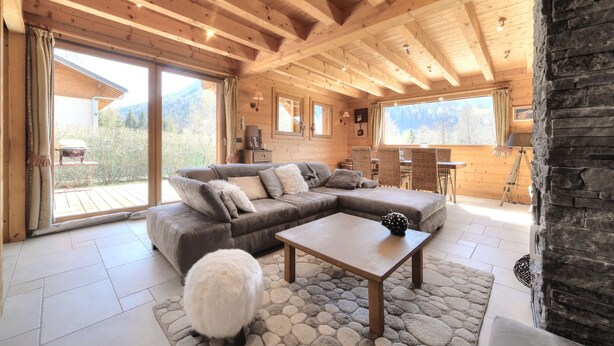 A cozy wooden interior with a sectional sofa, a coffee table, and a fluffy white rug. - Luxury mountain chalet for 8 people Saint Gervais close to amenities (Saint-Gervais-les-Bains)