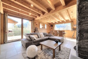 A cozy wooden interior with a sectional sofa, a coffee table, and a fluffy white rug. - Luxury mountain chalet for 8 people Saint Gervais close to amenities (Saint-Gervais-les-Bains)