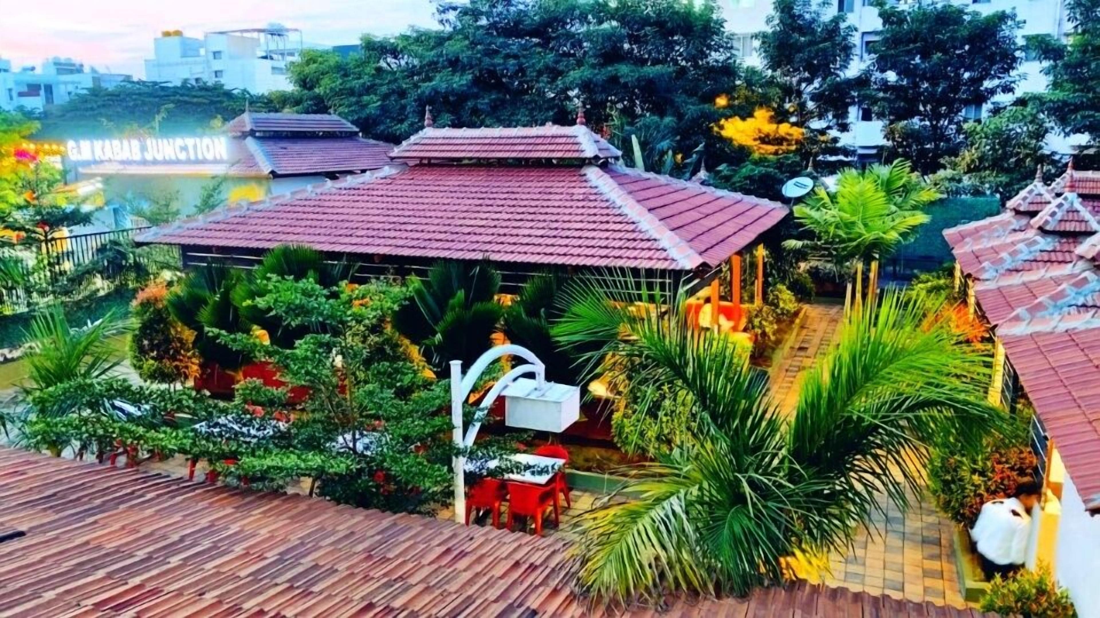 A rooftop garden with a gazebo, surrounded by lush greenery and a view of the city skyline.