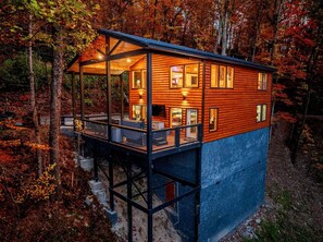 A wooden cabin with a balcony, surrounded by trees. - Charming Mountain Cabin with Hot Tub & Game Loft near Pigeon Forge, Tennessee (Sevierville)