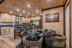 Ein Holzinterieur mit Essbereich, Küche und einem Gemälde an der Wand.