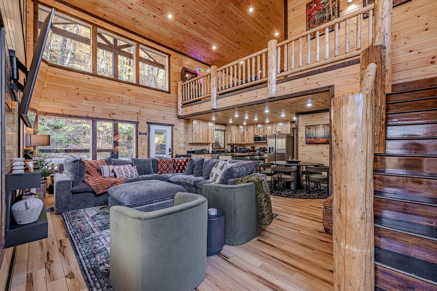 A spacious cabin interior with a large living area, a kitchen, and a balcony.
