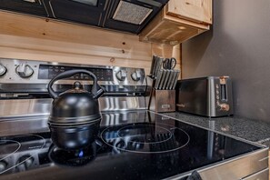 A kitchen with a black kettle, a toaster, and a knife block. - Charming Mountain Cabin with Hot Tub & Game Loft near Pigeon Forge, Tennessee (Sevierville)
