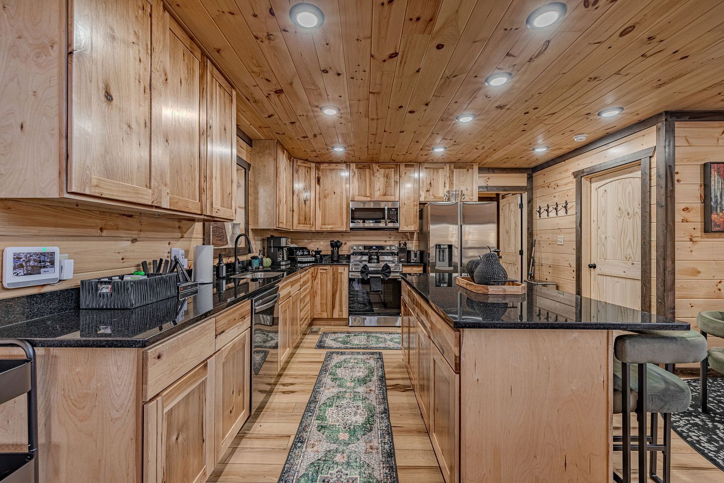 L’intérieur d’un chalet en bois comprend une cuisine, un coin repas et un bar avec des sièges.