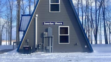 Un bâtiment triangulaire sur lequel on peut lire l’inscription « Sunrise Shore », entouré de neige et d’arbres sans feuilles.