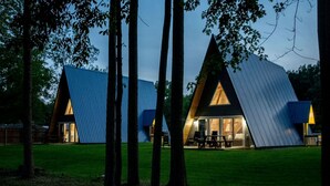 A modern, triangular-shaped building with a glass facade and a picnic table outside.