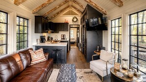 Una cocina amplia con una isla central, muebles oscuros y un ventanal grande.