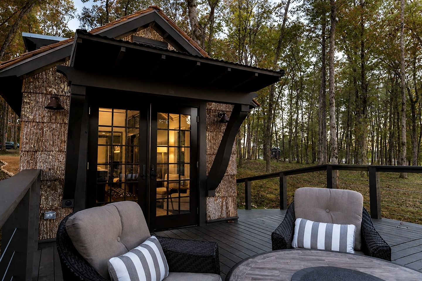 A wooden deck with outdoor seating and a glass door entrance to a building.