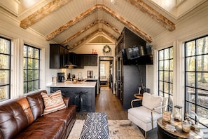 A spacious kitchen with a central island, dark cabinetry, and a large window.