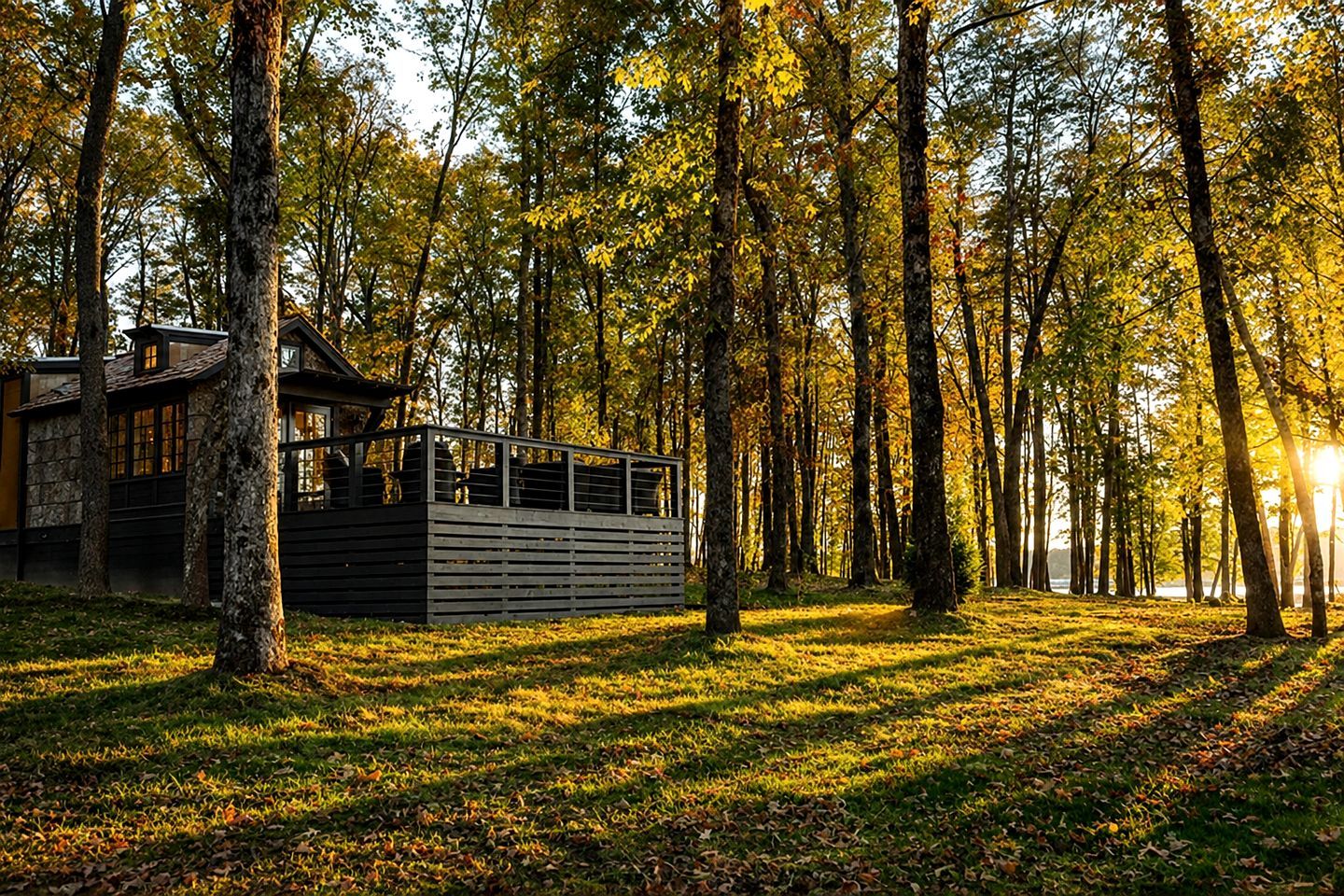 En stuga med en träveranda som omges av en skog.
