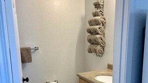 Un baño con inodoro, lavamanos y toallero.