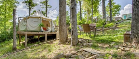 Un cadre extérieur rustique avec une terrasse en bois, un espace salon couvert et un chemin en pierre.