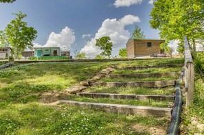 Un espacio con césped y escalones que conducen a una cabaña de madera.