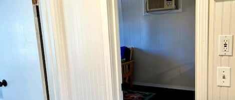 Una habitación con una puerta blanca, una bañera blanca y un ventilador de techo.