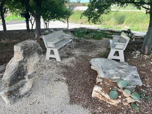 Two benches, a large rock, and a cactus in a landscaped area. - Family Style Glamping in Pet-Friendly Rental at Lake Godstone, Texas (Graford)