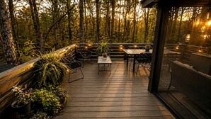 A wooden deck with outdoor furniture and potted plants. - Chic Tiny Cabin with Jacuzzi, Screened Porch and Grill in Tennessee (Tracy City)