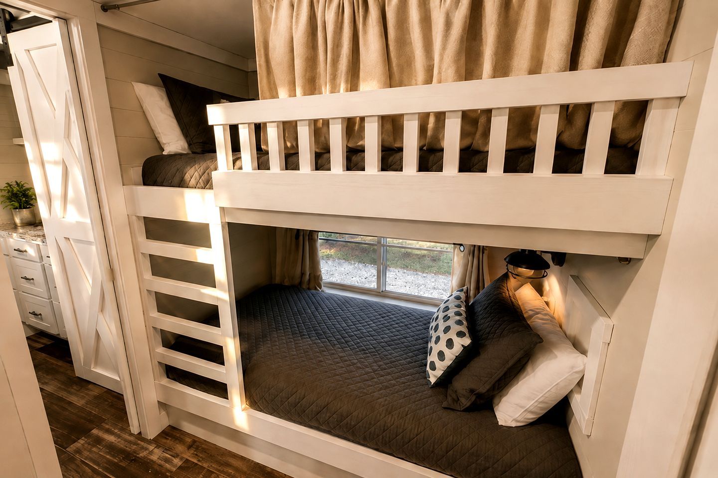 Una cama litera con ventana, cortinas y una lámpara de noche.