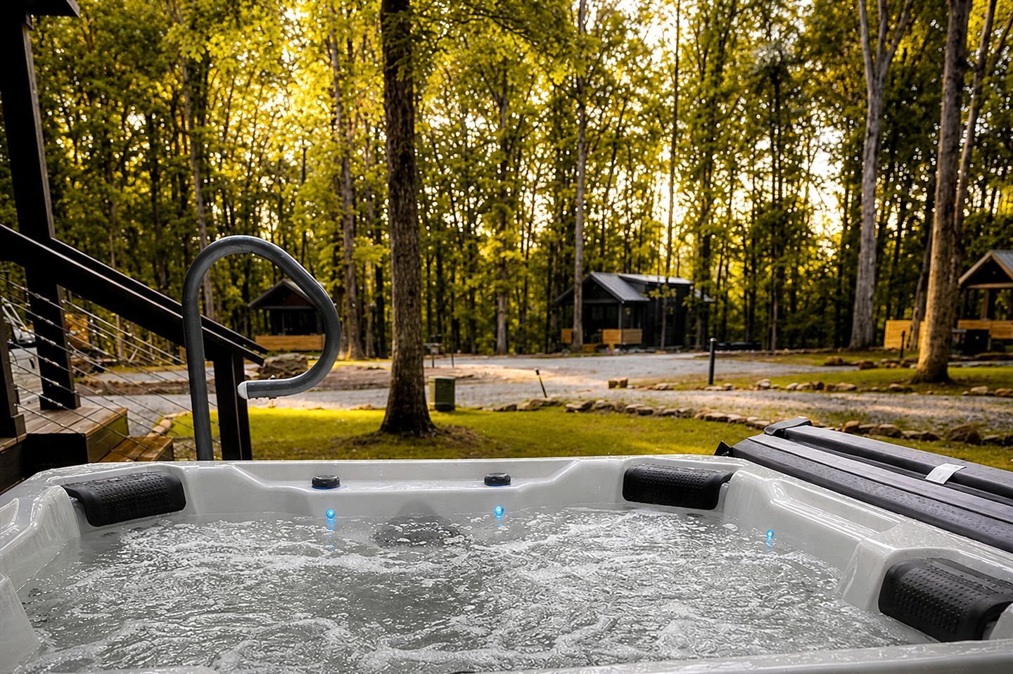 Ein Whirlpool mit Blick auf eine bewaldete Landschaft und ein Blockhaus im Hintergrund.