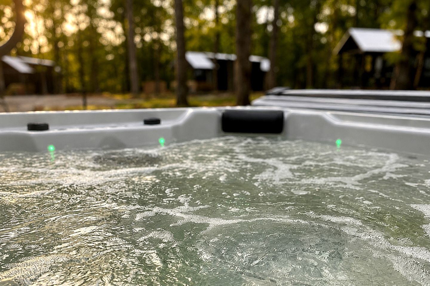 A hot tub with water jets in a forested area.