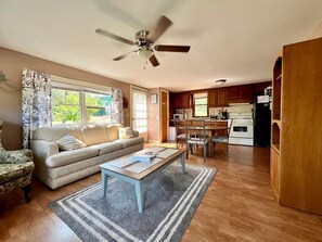 Ein Wohnzimmer mit einer Couch, einem Couchtisch und einem Essbereich mit Stühlen und einem Tisch.