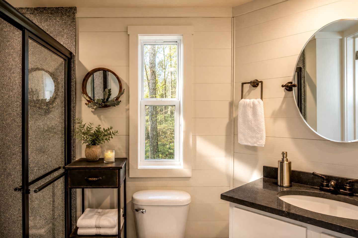 Ein Badezimmer mit Toilette, Waschbecken, Spiegel und Fenster.