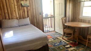 Un dormitorio con una cama, una mesita y una silla.