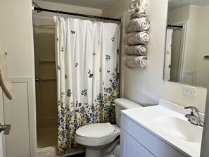 Ein Badezimmer mit Toilette, Waschbecken, Duschvorhang und Handtüchern.