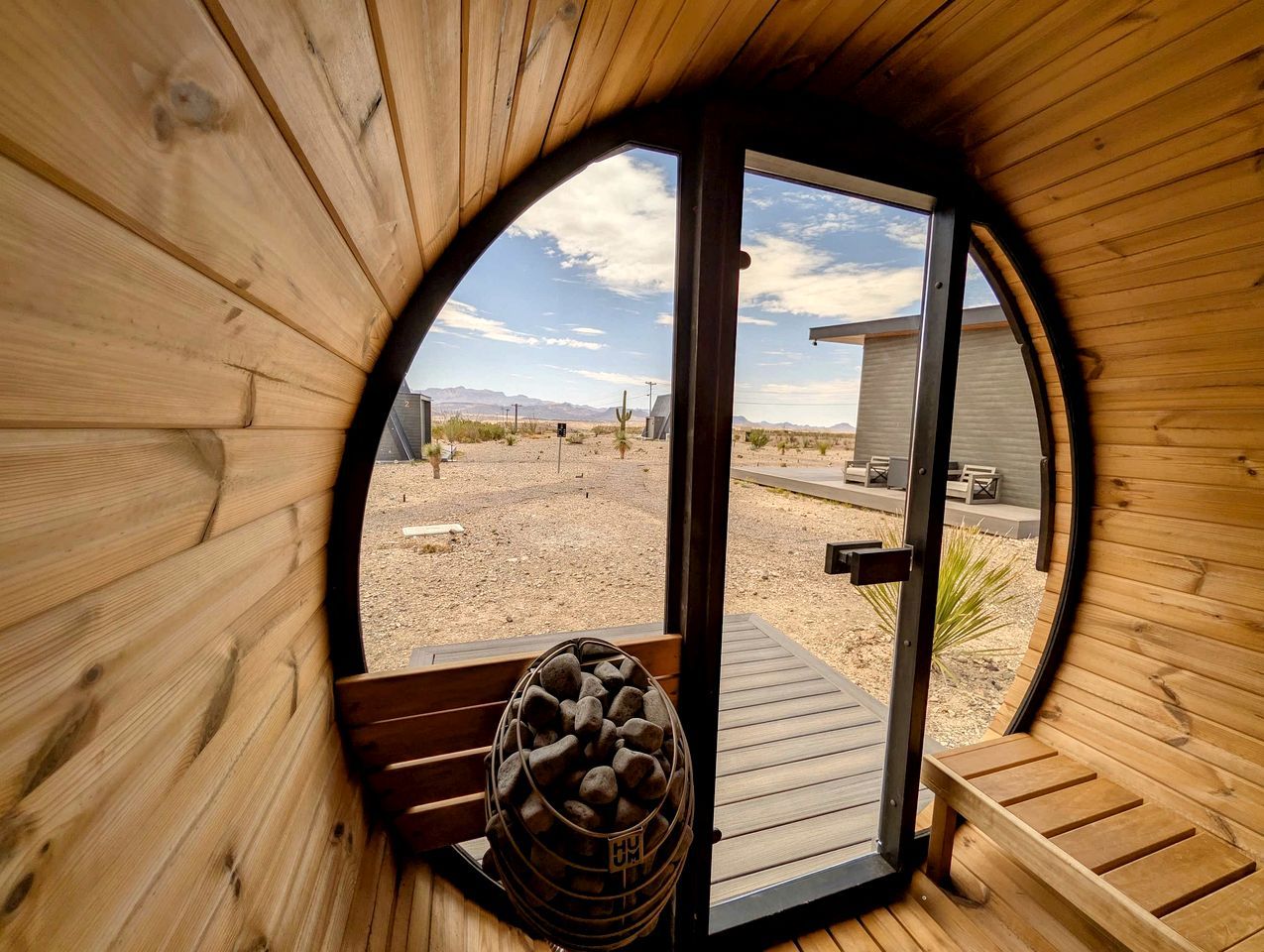 Una habitación circular de madera con una puerta que da al exterior.
