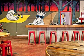 A bar area with two white animal figures, red stools, and a wooden table. - Glorious Cabin with Stunning Sights in Monteagle, Tennessee (Monteagle)