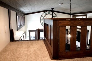 A room with a wooden ceiling, a large clock, and a view of a staircase. - Glorious Cabin with Stunning Sights in Monteagle, Tennessee (Monteagle)