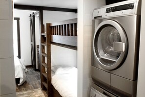 A compact room with a bunk bed, a washing machine, and a small kitchenette. - Glorious Cabin with Stunning Sights in Monteagle, Tennessee (Monteagle)